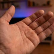 Une paume de main ouverte présentée devant un arrière-plan flou de salon.