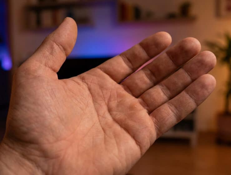 Une paume de main ouverte présentée devant un arrière-plan flou de salon.