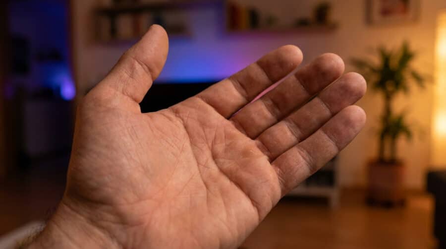 Une paume de main ouverte présentée devant un arrière-plan flou de salon.